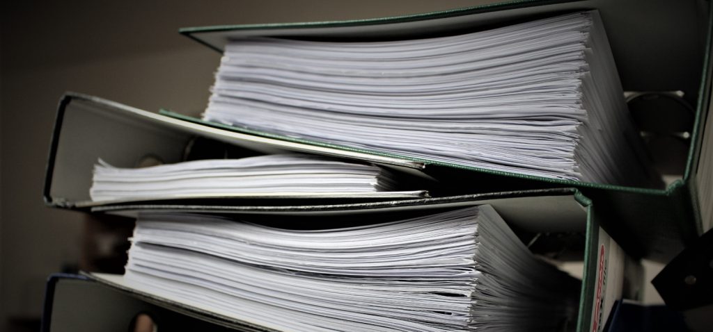 Segregatory z dokumentami poukładane jeden na drugim